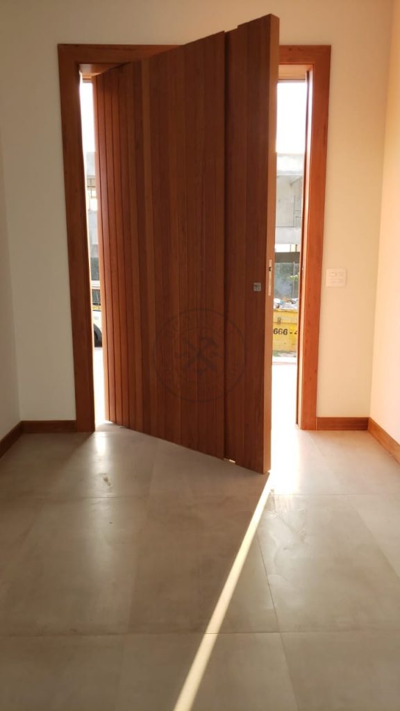 Porta pivotante de lambril de Angelin Pedra com puxador cava na própria madeira - Imagem 5