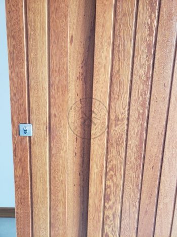 Porta pivotante de lambril de Angelin Pedra com puxador cava na própria madeira - Imagem 6