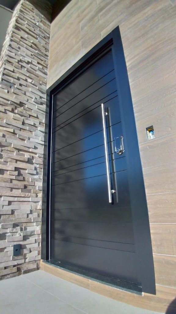 Porta pivotante em ACM preto carbono com frisos horizontais e dupla vedação - Imagem 2