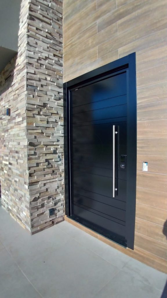 Porta pivotante em ACM preto carbono com frisos horizontais e dupla vedação - Imagem 3