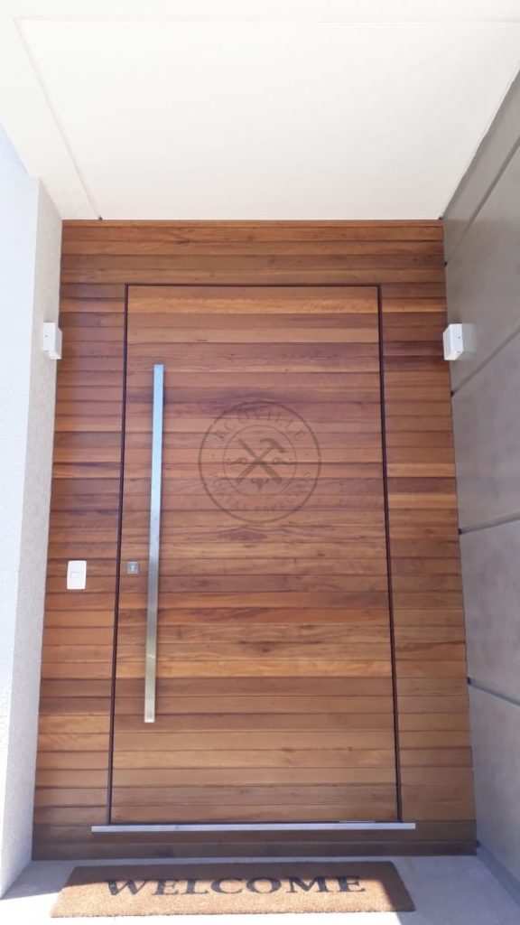 Porta pivotante com bandeira e painéis fixos de Lambril de Cedro