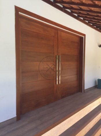 Porta com sistema de correr embutido, sendo com duas folhas de correr em madeira maciça