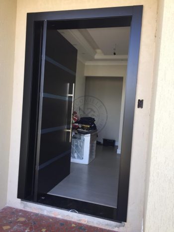 Porta pivotante com revestimento em MDF, frisos com acabamentos em inox e pintura laca preto acetinado - Imagem 2