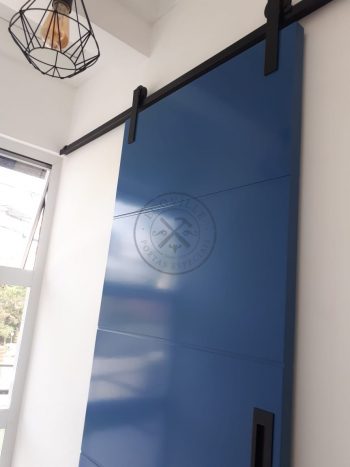 Porta de correr com trilho aparente e revestimento em MDF com pintura laca P.U azul acetinado - Imagem 4