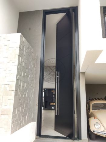 Porta pivotante em ACM preto carbono com frisos horizontais e dupla vedação