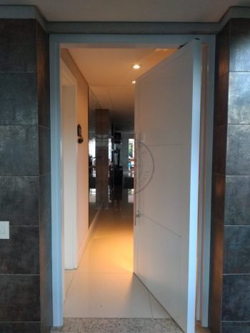 Porta pivotante em ACM branco neve com frisos horizontais e dupla vedação - Imagem 3