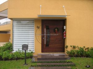 Porta pivotante reforçada com metalon de ferro, revestida com lambril de imbuia, visor de vidro fumê - Imagem 3