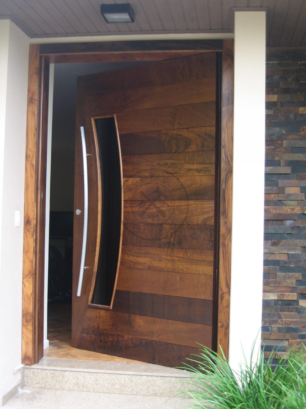 Porta pivotante reforçada com metalon de ferro no interior, revestido com lambril de imbuia, visor de vidro fumê - Imagem 4