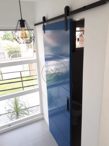 Porta de correr com trilho aparente e revestimento em MDF com pintura laca P.U azul acetinado - Imagem 6