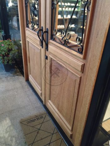 Porta com sistema de abertura dupla feita em madeira maciça com grades decorativas de ferro - Imagem 6