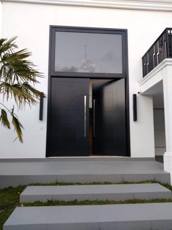 Porta pivotante em ACM preto carbono com almofadas e sistema de abertura dupla com bandeira superior de vidro temperado - Imagem 6