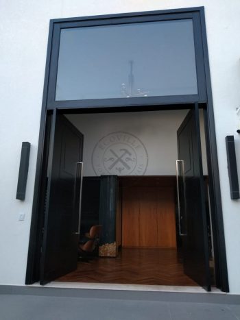 Porta pivotante em ACM preto carbono com almofadas e sistema de abertura dupla com bandeira superior de vidro temperado - Imagem 7