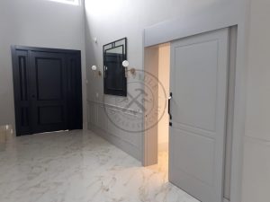Porta pivotante com revestimento em MDF, apliques de moldura e pintura laca preto acetinado - Imagem 5