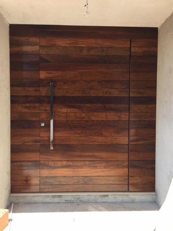 Porta pivotante de lambril de Imbuia com painel lateral fixo seguindo modelo da porta