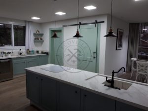 Porta de correr com trilho aparente e revestimento em MDF com pintura laca P.U verde acetinado