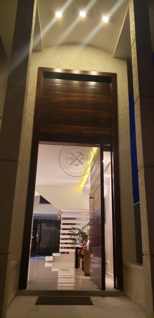 Porta pivotante de lambril de Imbuia com bandeira superior fixa seguindo o mesmo modelo da porta - Imagem 11