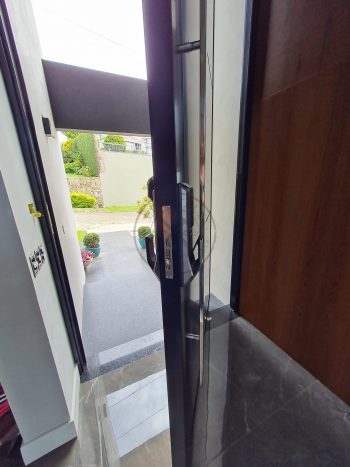 Porta pivotante em ACM preto carbono com borda e frisos horizontais e dupla vedação - Imagem 7