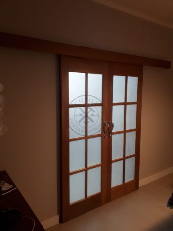 Porta com sistema de correr embutido em madeira maciça com visores de vidro - Imagem 7
