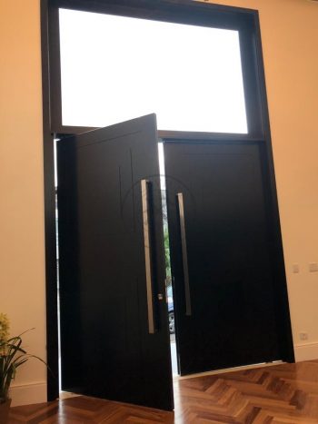 Porta pivotante em ACM preto carbono com almofadas e sistema de abertura dupla com bandeira superior de vidro temperado - Imagem 8