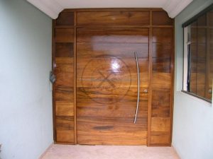 Porta pivotante com estrutura de ferro no interior, revestido com lambril de Imbuia