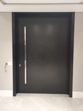 Porta pivotante em ACM preto carbono com um friso vertical e um friso horizontal, bandeira superior e dupla vedação - Imagem 10