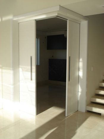 Porta com sistema de correr embutido sendo duas folhas móveis com fechamento central - Imagem 3