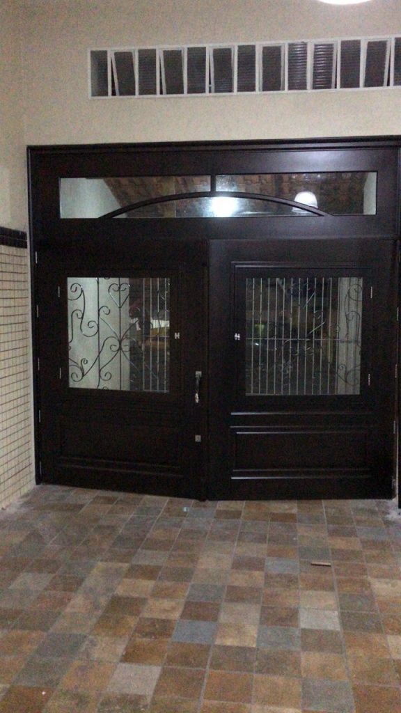 Porta com sistema de abertura dupla maciça com grade de ferro e vidro - Imagem 4
