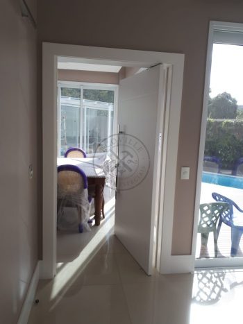 Porta pivotante com revestimento em MDF, frisos horizontais e pintura laca branco acetinado