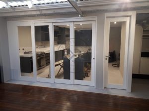 Porta com sistema de correr embutido sobrepostas com vidro panorâmico incolor