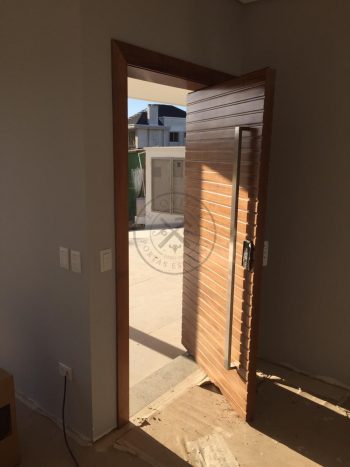 Porta pivotante de lambril maciço com painéis e bandeira seguindo o mesmo alinhamento da porta - Imagem 6