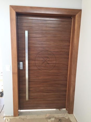 Porta pivotante de lambril maciço com painéis e bandeira seguindo o mesmo alinhamento da porta - Imagem 7