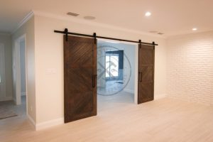 Porta com sistema de correr aparente, madeira maciça de Imbuia, sendo duas folhas móveis