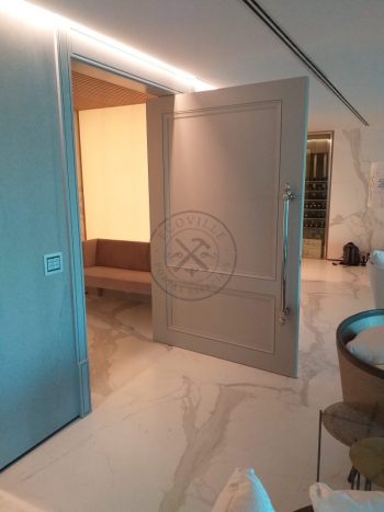 Porta pivotante com revestimento em MDF, aplique de molduras e pintura laca cinza acetinado