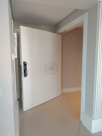 Porta pivotante com revestimento em MDF com frisos verticais e pintura laca branco acetinado