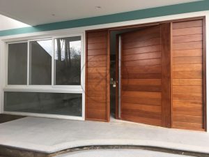 Porta em madeira maciça com frisos horizontais e portal duplo lateral - Imagem 2