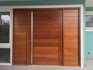 Porta em madeira maciça com frisos horizontais e portal duplo lateral