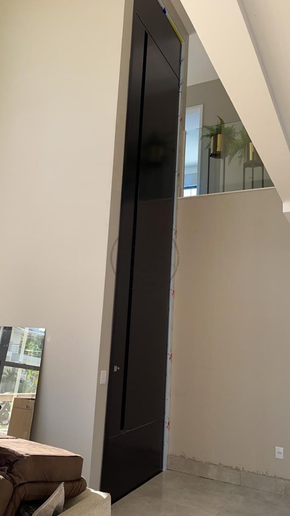Porta pivotante em ACM preto carbono com puxador cava e dupla vedação. - Imagem 2