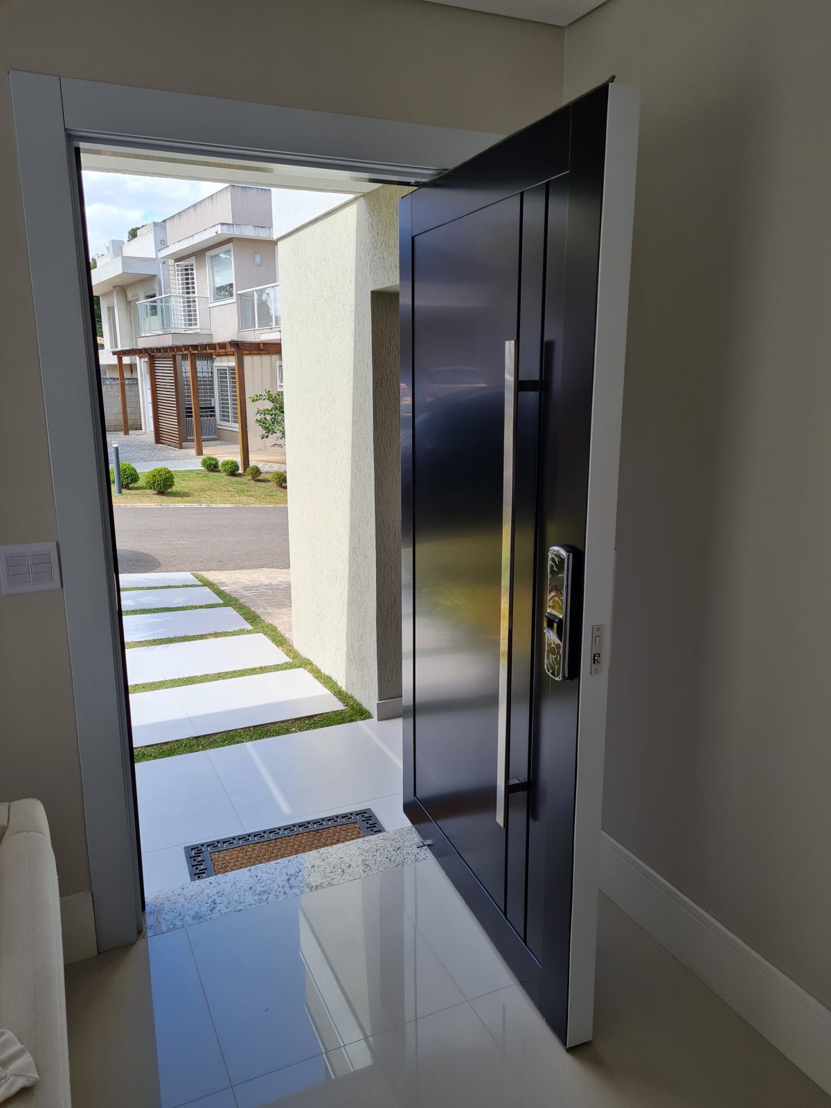 Porta pivotante em ACM preto carbono lado externo e branco neve lado interno - Imagem 5