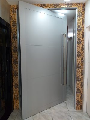 Porta pivotante em ACM cinza, modelo com bordas laterais e frisos horizontais