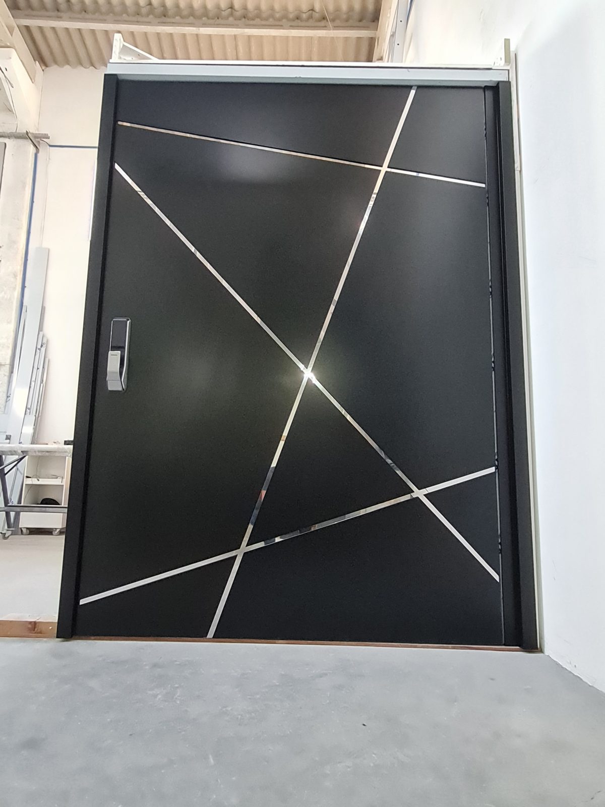 20210726_163329 Porta pivotante em ACM preto carbono com detalhes abstratos em inox e dupla vedação - Imagem 1