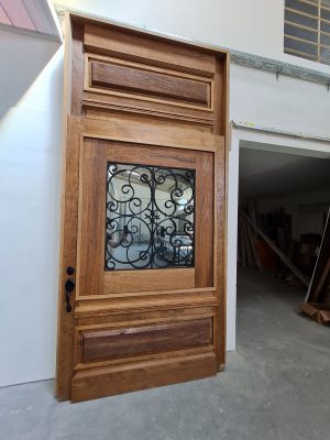 Porta pivotante com grade colonial preta, vidro 10 mm jateado, bandeira superior com almofada, pintura verniz P.U acetinado