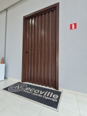Porta pivotante em ACM Sucupira, modelo ripado na vertical com dupla vedação - Imagem 2