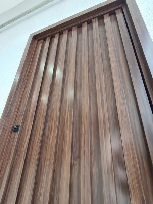 Porta pivotante em ACM Sucupira, modelo ripado na vertical com dupla vedação - Imagem 6