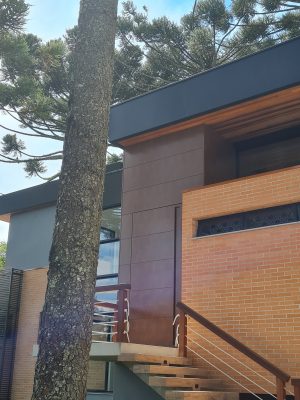Porta pivotante em ACM aço corten com frisos horizontais, puxador cava e dupla vedação - Imagem 10