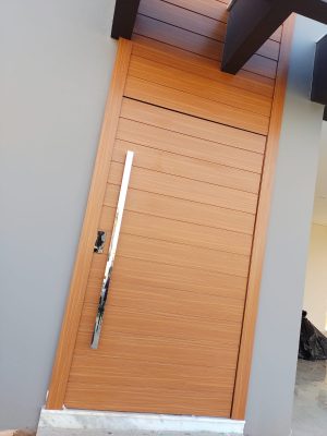 Porta pivotante em ACM amadeirado com bandeira superior e frisos horizontais com dupla vedação - Imagem 3
