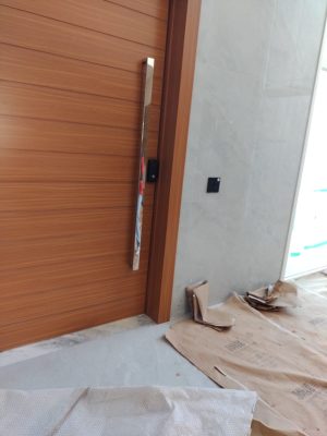 Porta pivotante em ACM amadeirado com bandeira superior e frisos horizontais com dupla vedação - Imagem 7