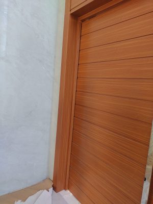 Porta pivotante em ACM amadeirado com bandeira superior e frisos horizontais com dupla vedação - Imagem 9