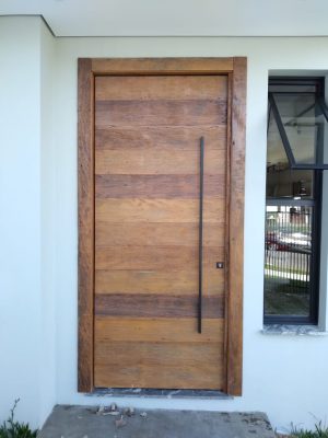 Porta pivotante com estrutura de aço no interior, revestimento com madeira de demolição Peroba Rosa do Campo, porta com 8 cm de espessura