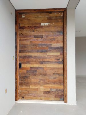 Porta pivotante com estrutura de aço no interior, revestimento com madeira de demolição Peroba Rosa do Campo, porta com 8 cm de espessura