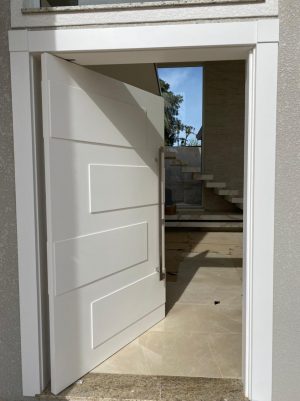 Porta pivotante com revestimento em MDF e apliques em 3D com pintura laca branca P.U acetinado